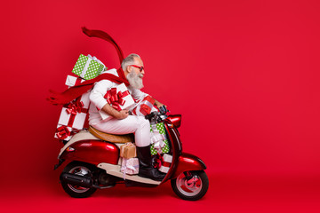 Profile side view of his he nice attractive trendy purposeful gray-haired man riding moto bike delivering pile stack purchase air wind blows isolated on bright vivid shine red background