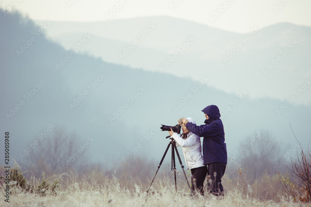 photographers with cameras outdoor making landscape pictures
