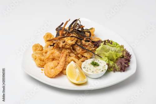 Crispy crunchy breaded crumbs coating Fried Shrimps on white plate, Breaded shrimps plate with tartar sauce isolated on white background