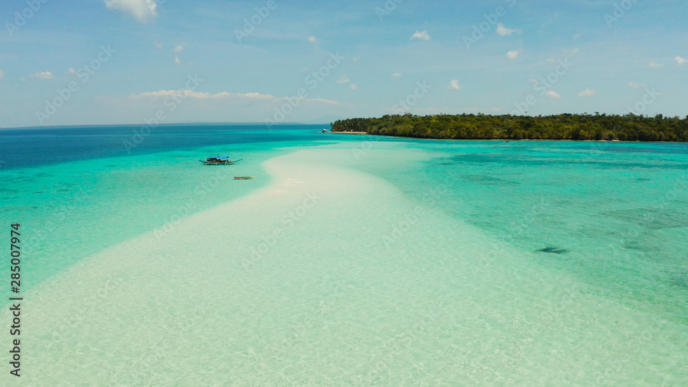 Seascape with a beautiful beach and tropical island surrounded by a coral atoll with turquoise water. Mansalangan sandbar. Summer and travel vacation concept. Balabac, Palawan, Philippines.