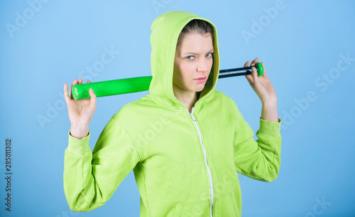 Woman play baseball game or going to beat someone. Baseball female player concept. She is dangerous. Girl hooded jacket hold baseball bat blue background. Brutal and bully. Woman in baseball sport © be free