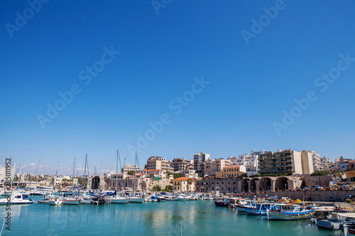 The harbor of Heraklion with ruins of Venetian era buildings and numerous yachts and boats in port, Crete, Greece. © Pitcher