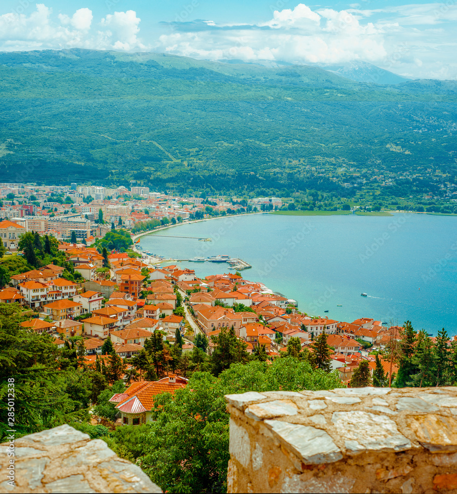 North macedonia. Ohrid. Different buildings and houses with red roofs on lake shore on mountains background