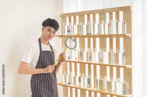 Asian young salesman and fisherman at the fish shop beautiful. for those who are interested in buying fish for a hobby.