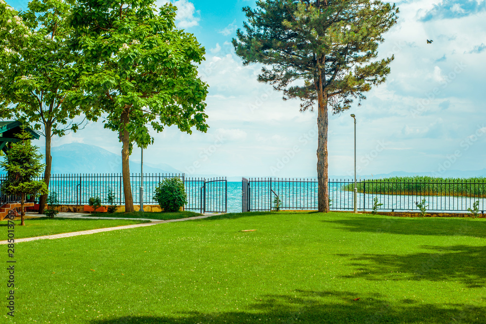 North macedonia. Ohrid. Path through green lawn to gate and lake in sunny day