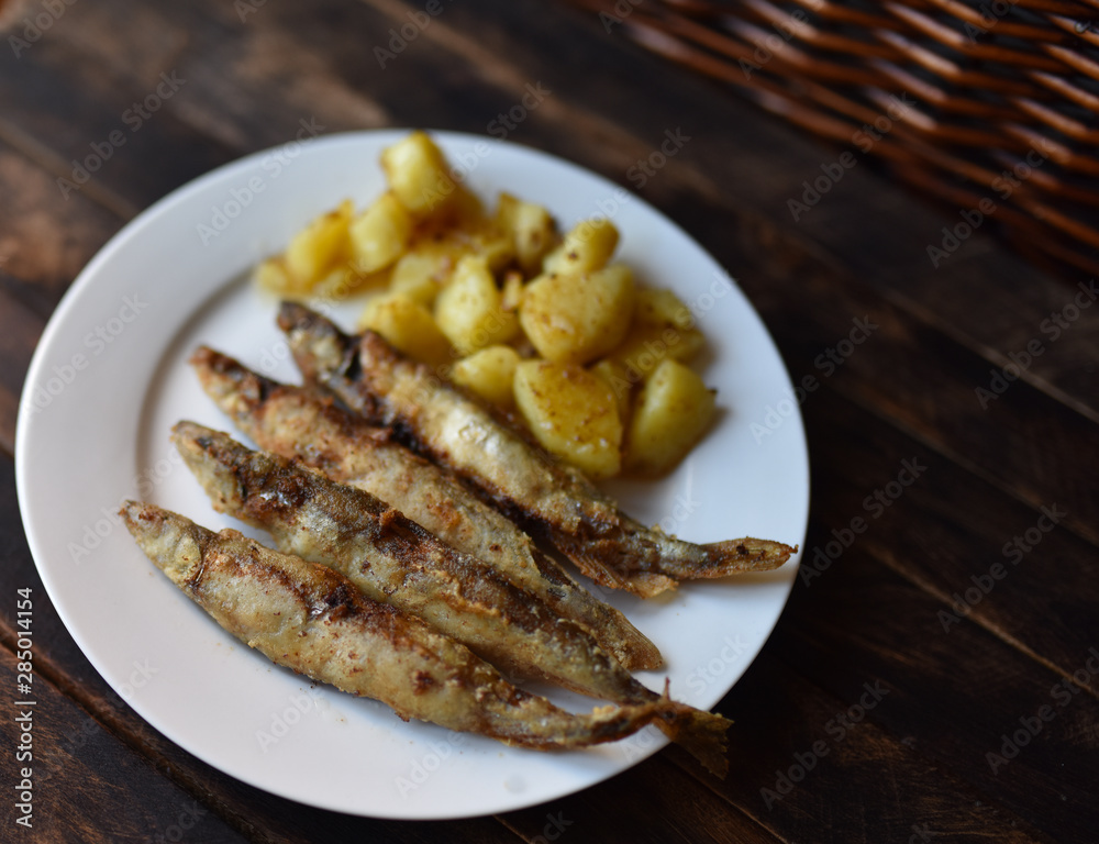 fried fish with potatoes on a wooden table top view fried fish with potatoes on a wooden table top view