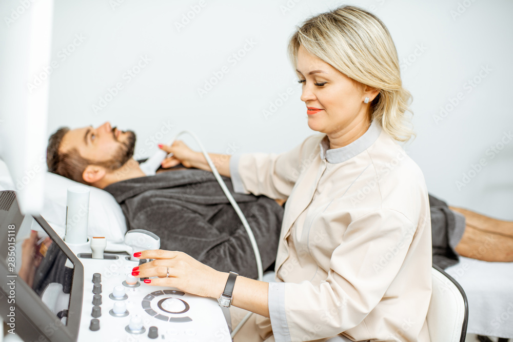 Doctor examining men's thyroid with ultrasound Doctor examining men's thyroid with ultrasound