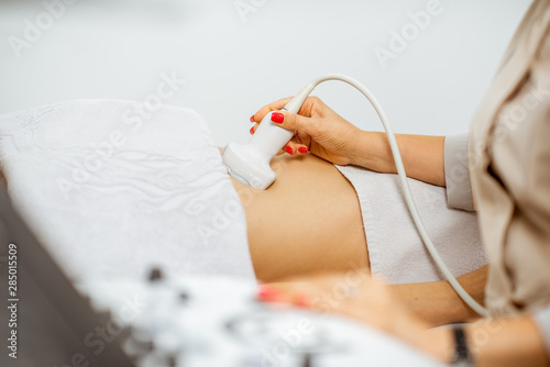 Doctor performs ultrasound examination of a woman photo