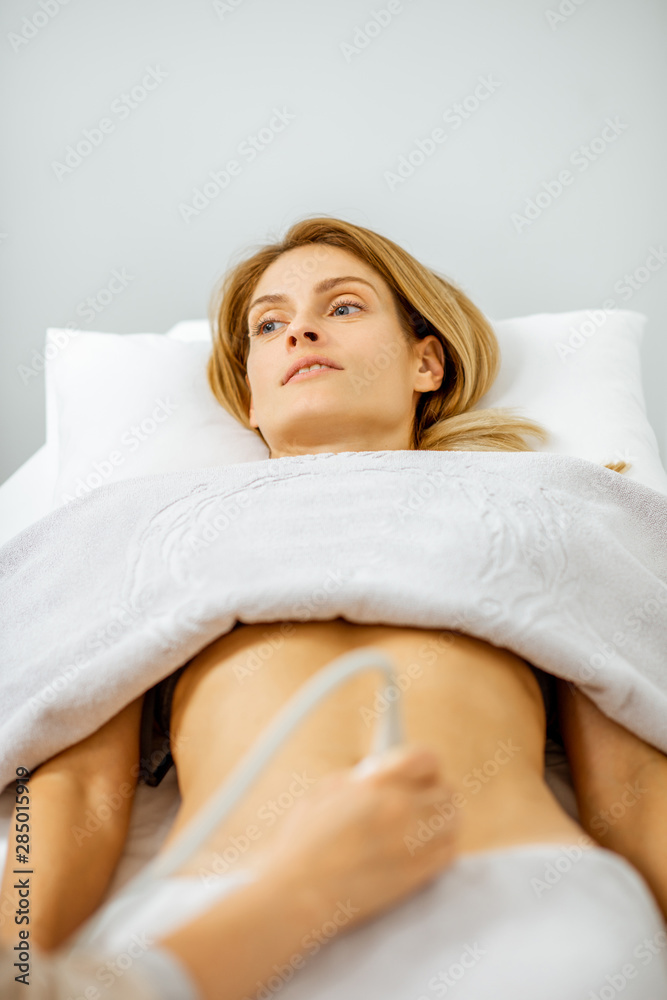 Woman examining her abdomen with ultrasound Woman examining her abdomen with ultrasound