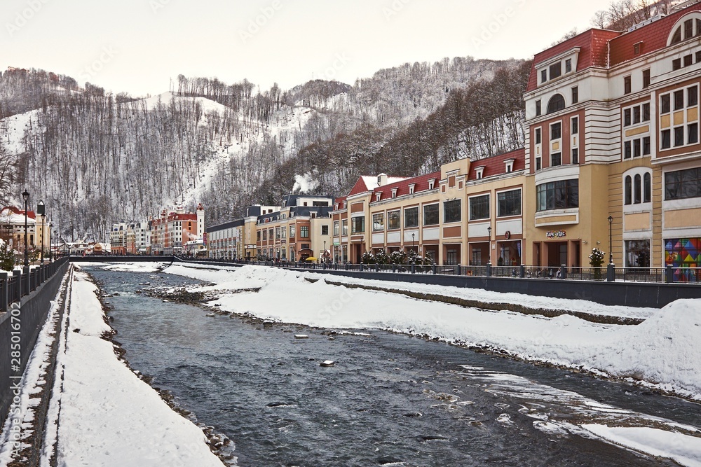 Winter in a settlement in the mountains by the river