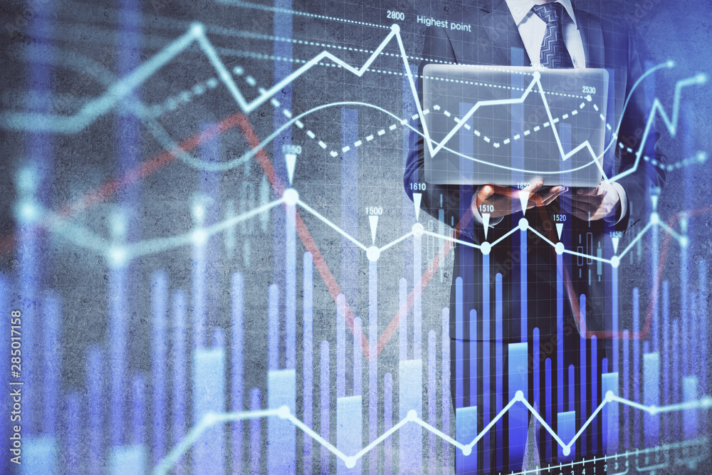 Fototapeta premium Forex graph with businessman working on laptop on background. Concept of hardworking. Multi exposure.