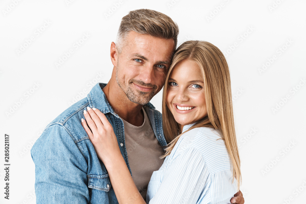 Portrait of young caucasian couple man and woman in basic clothing smiling and hugging together Portrait of young caucasian couple man and woman in basic clothing smiling and hugging together