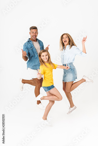 Full length photo of joyous caucasian family woman and man with little girl smiling and having fun together