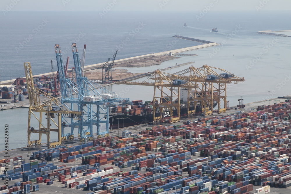 Editorial photography of  a Cargo being loaded in the harbor of Barcelona in Spain. Panorama picture with many containers and cranes.