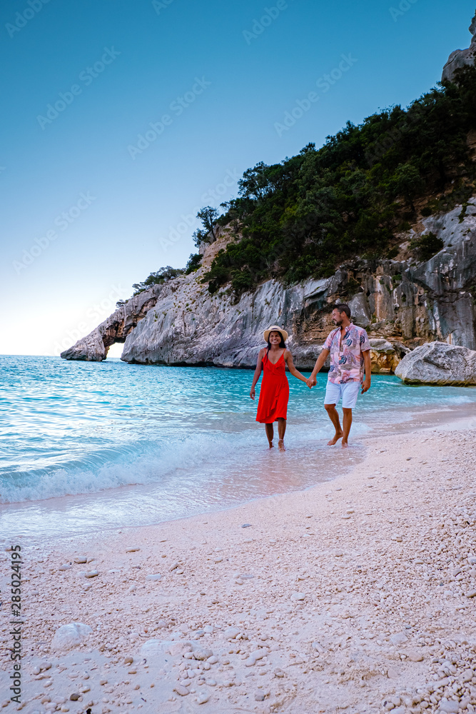 Φωτογραφία young couple on vacation Sardinia, men and woman walking on the beach of Cala Go