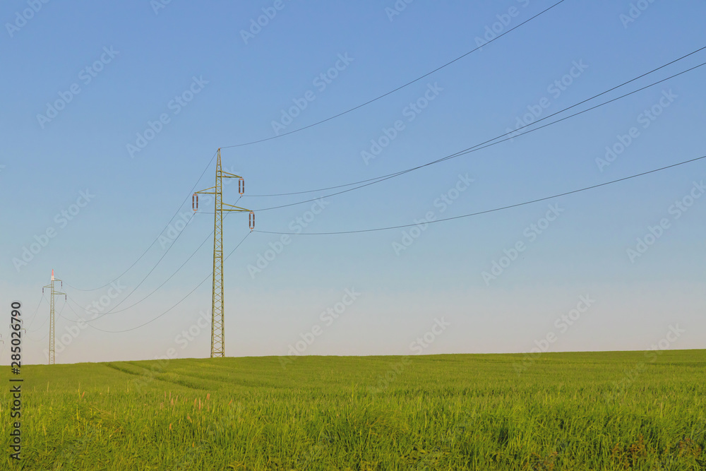 Power line and green field with blue sky Power line and green field with blue sky