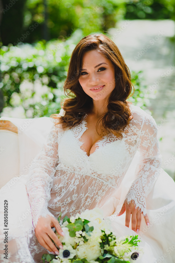 Close-up portrait of young beautiful bride in white negligee with bridal bouquet Close-up portrait of young beautiful bride in white negligee with bridal bouquet