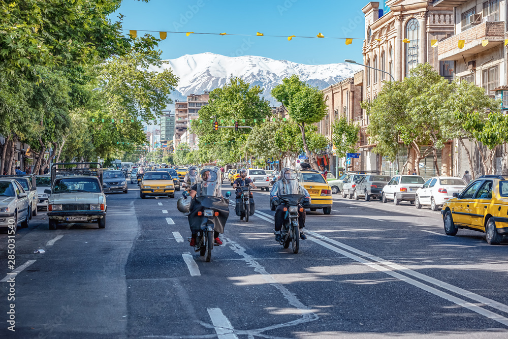 06/05/2019 Tehran,.Tehran Province,.Iran, high traffic in crowded street of capital of Islamic Republic навпроти Alborz Mountains on background.