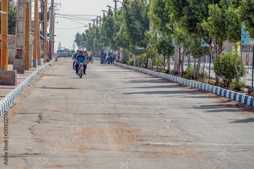 11/05/2019 Hormuz, Hormozgan Province, Iran, motorcyclists ride along the avenue on a sunny and hot day.