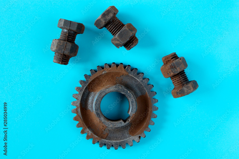 Rusty bolts, nuts and gear wheel made of chocolate isolated on sky blue background. Mechanic gearing background. Father's day card obects Rusty bolts, nuts and gear wheel made of chocolate isolated on sky blue background. Mechanic gearing background. Father's day card obects