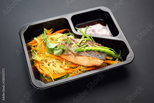 Grilled salmon fillet on pasta. Takeaway dish