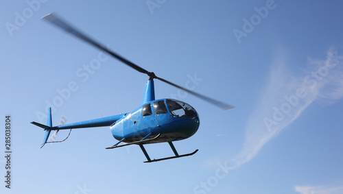 The aircraft - Blue small helicopter makes flight low  height