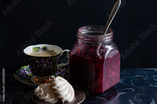 jam in a jar, tea and cake on a dark background