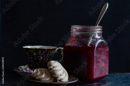 jam in a jar, tea and cake on a dark background