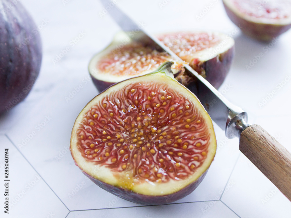 ripe figs with a knife on a marble table ripe figs with a knife on a marble table