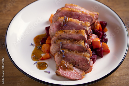 Sliced duck breast fillet with sweet potatoes and  beetroot on plate