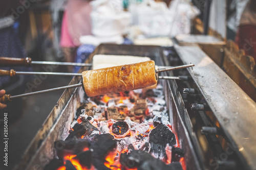 Photography Chimney cakes (Kurtoskalacs) cooking on ember on Christmas market