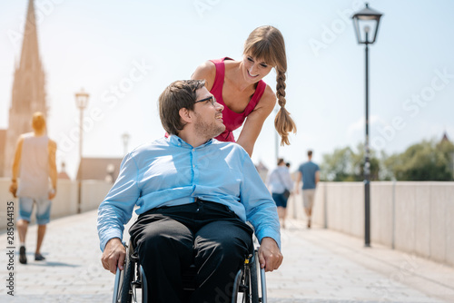 Woman and disabled man having a walk photo