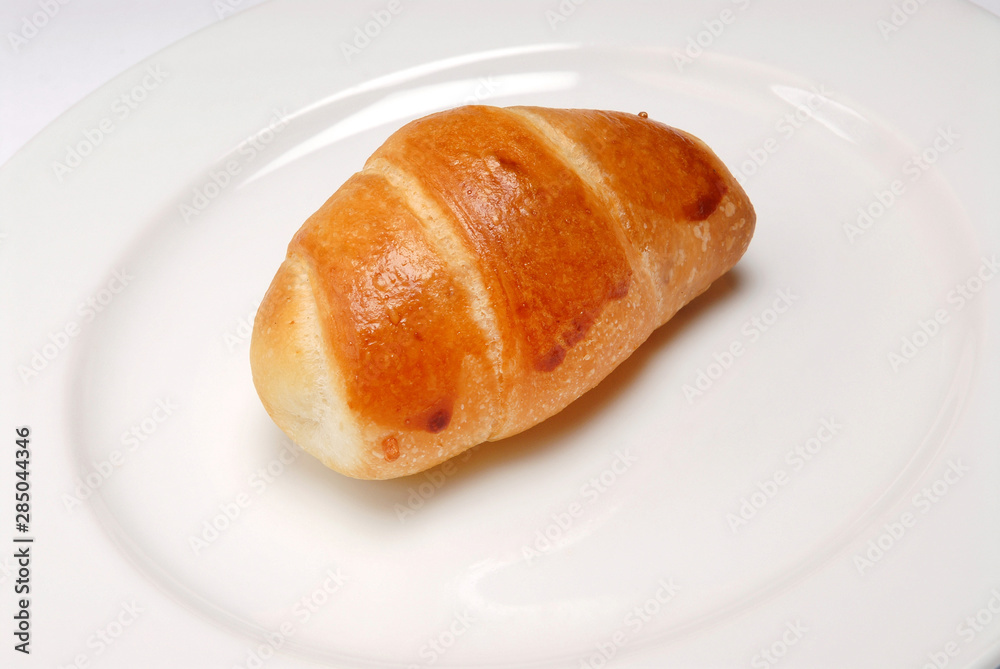 Delicious sesame croissant on plate on gray background Delicious sesame croissant on plate on gray background