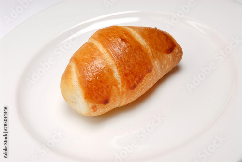 Delicious sesame croissant on plate on gray background