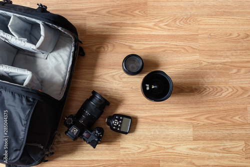 Photographer equipment is lying on the floor by the backpack.