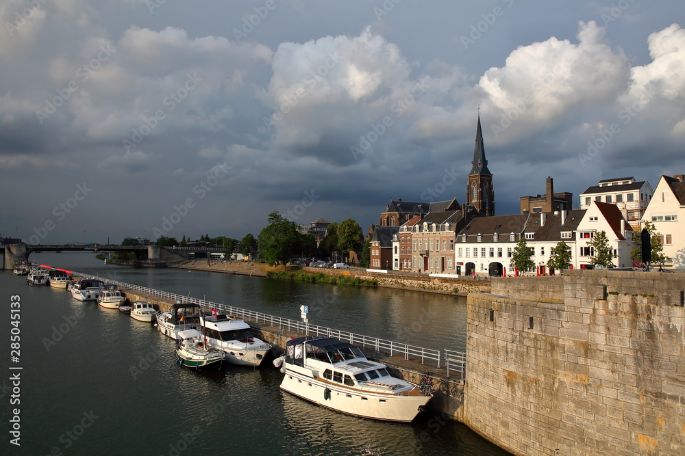 Historic buildings and Sint Martinuskerk church located in Wyck neighborhood along the Meuse river and viewed from the 13th century roman bridge Sint Servaasbrug, Limbourg, Maastricht, Netherlands