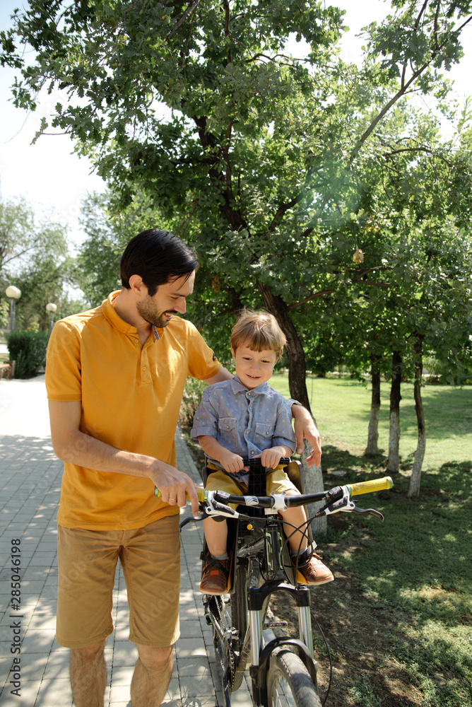 Bicycle ride of father and his son on baby seat Bicycle ride of father and his son on baby seat