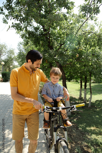 Bicycle ride of father and his son on baby seat