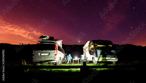 Quadro su tela Campervans are parked on a beach at night under stars.