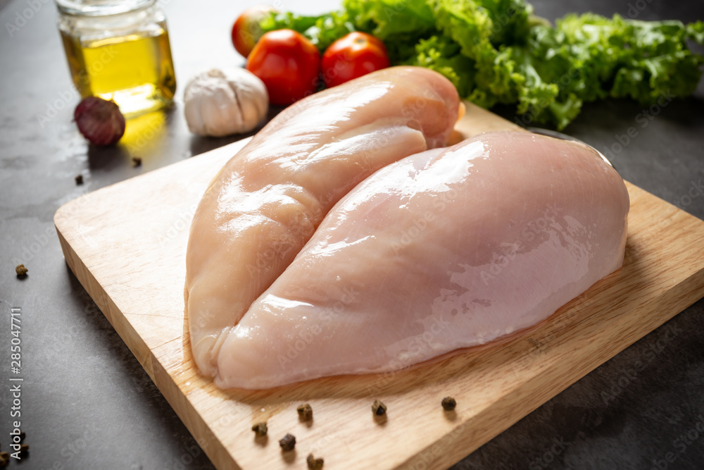 Raw chicken breasts on wooden cutting board. Raw chicken breasts on wooden cutting board.