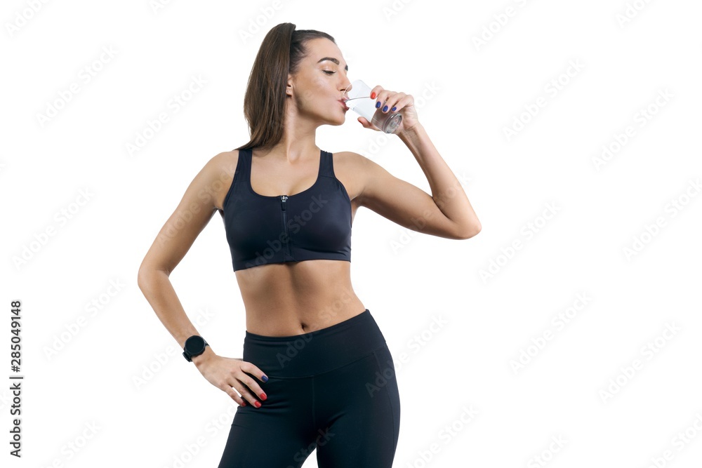 Isolated portrait of young woman in sportswear drinking water Isolated portrait of young woman in sportswear drinking water