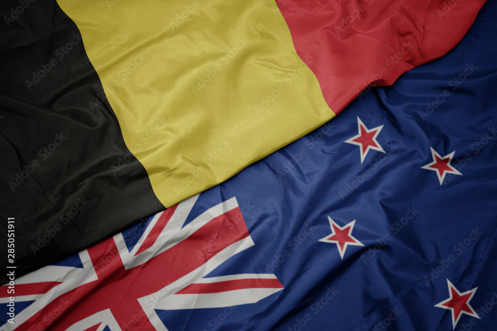 waving colorful flag of new zealand and national flag of belgium. waving colorful flag of new zealand and national flag of belgium.
