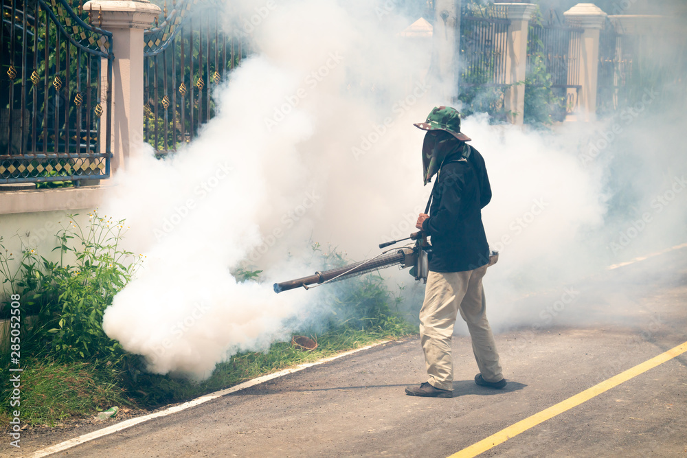 Obraz premium man use fumigation mosquitoes machine for kill mosquito carrier of Zika and dengue fever around the house