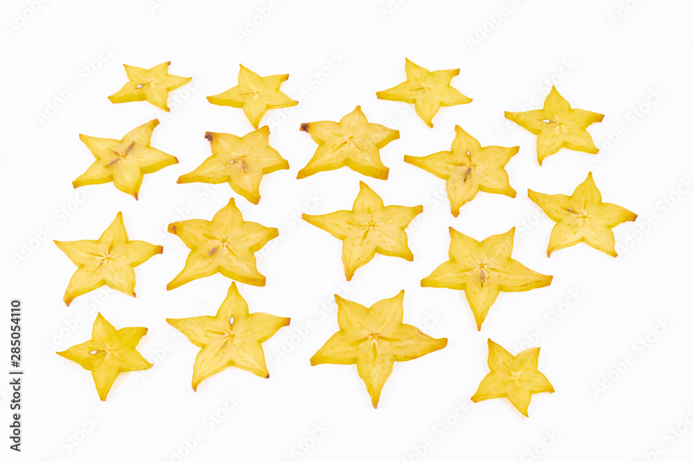Many slices of star fruit scattered on a white background - Averrhoa carambola - Ripe carambola Many slices of star fruit scattered on a white background - Averrhoa carambola - Ripe carambola