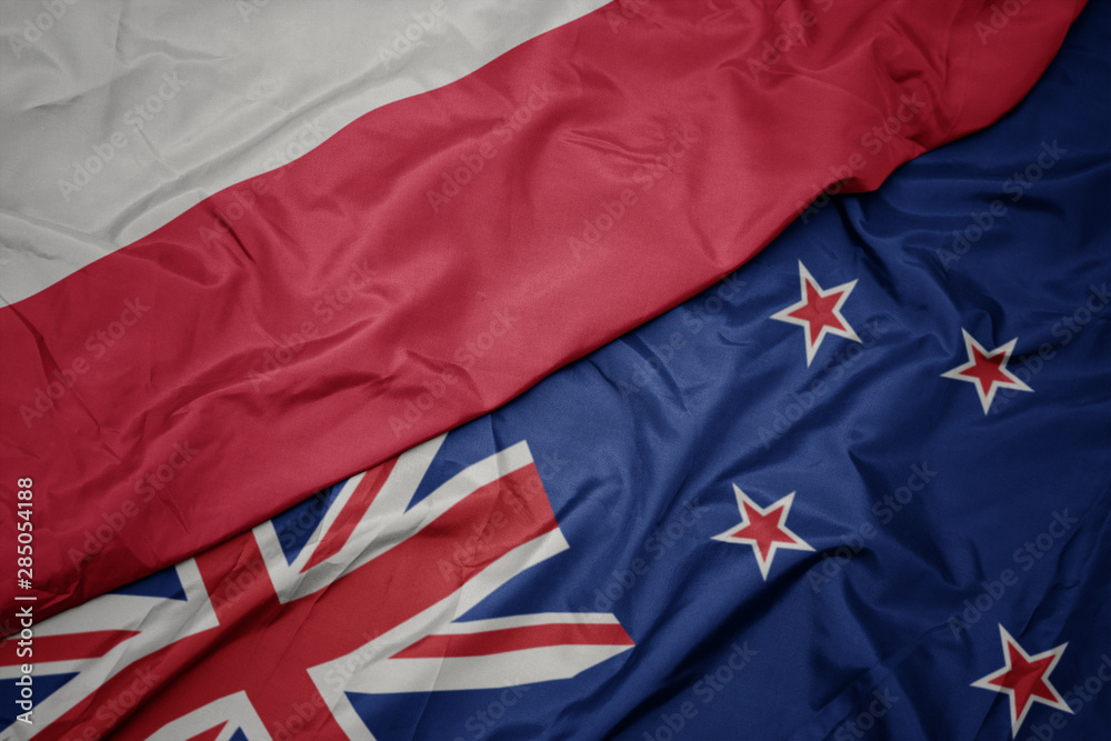 waving colorful flag of new zealand and national flag of poland. waving colorful flag of new zealand and national flag of poland.