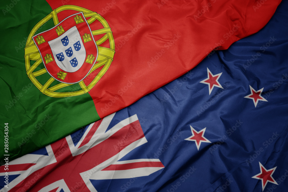 waving colorful flag of new zealand and national flag of portugal. waving colorful flag of new zealand and national flag of portugal.