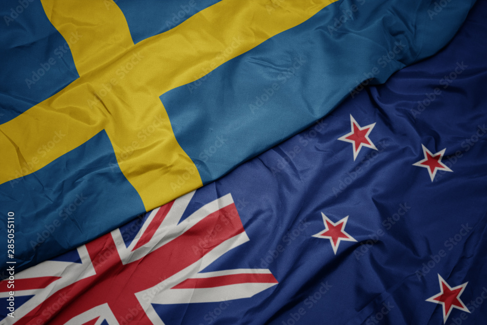 Fototapeta premium waving colorful flag of new zealand and national flag of sweden.