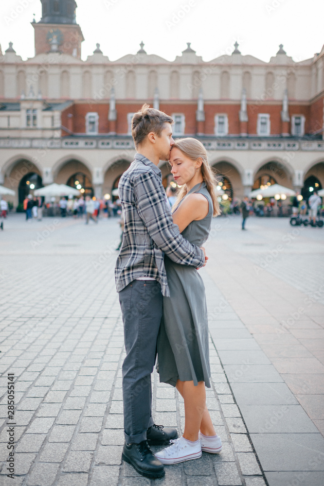 Young loving couple hugs at central square in Krakow (Cracow).