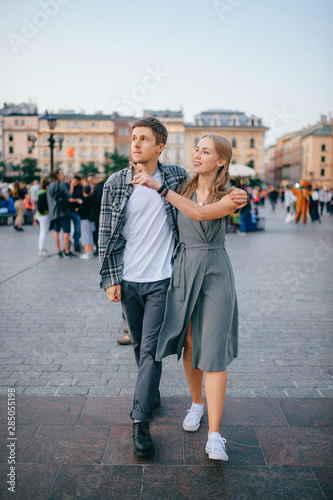 Happy loving couple smiling and walking throug the main square in Krakow (Cracow) © benevolente
