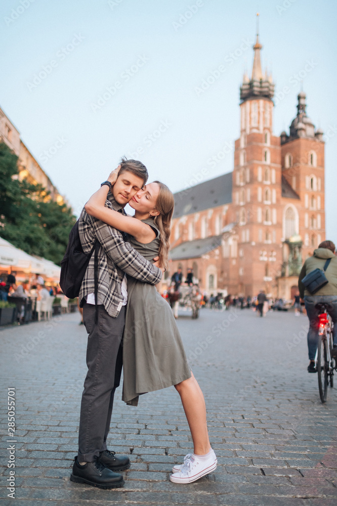 Obraz premium Young loving couple hugs at central square in Krakow (Cracow).